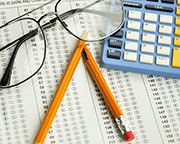 Glasses, calculator, bubble test sheet, and a broken pencil.