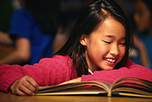 Smiling girl reading a book