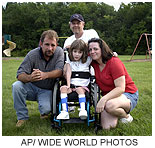 little girl in wheelchair with family
