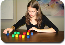A student uses colored cubes