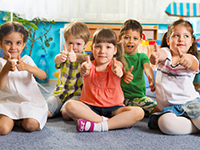 group of children giving the thumbs up