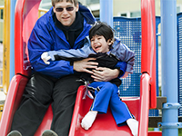 adult helping child on slide