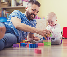 dad playing with child on floor