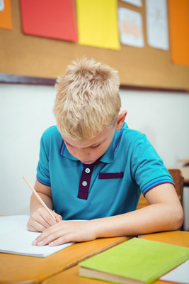Boy writing at his desk.