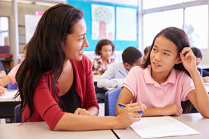 Woman helping girl with assignment