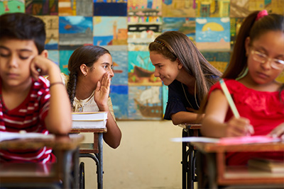 girl whispering in class