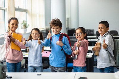 bunch of kids giving a thumbs up