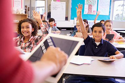 classroom with boy raising his hand