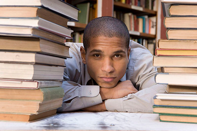 Boy looking between two stacks of books